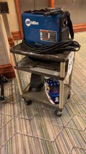 MILLER MAXSTAR 200 WITH WELDING HELMETS AND CART (LOCATION: MAIN LOBBY BY ELEVATOR)