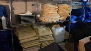 LOT OF ASSTD TABLE TOPS , CLOTH NAPKINS & CATERING UNIFORMS WITH RACKS (LOCATION: 1ST FLOOR THURGOOD MARSHALL BALLROOM)