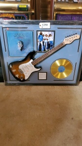 FRAMED EAGLES MEMORABILIA WITH ELECTRIC GUITAR AND “THEIR GREATEST HITS” RECORD (SIGNATURE IS UNAUTHENTICATED) (43X35)