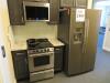 LOT GENERAL ELECTRIC 2 DOOR REFRIGERATOR WITH ICE MAKER, HAIER MICROWAVE, AND WHIRLPOOL ELECTRIC STOVE, (UP-STAIRS)